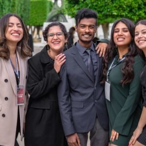 A group of diverse colleagues smiling together, showcasing teamwork and friendship outdoors.